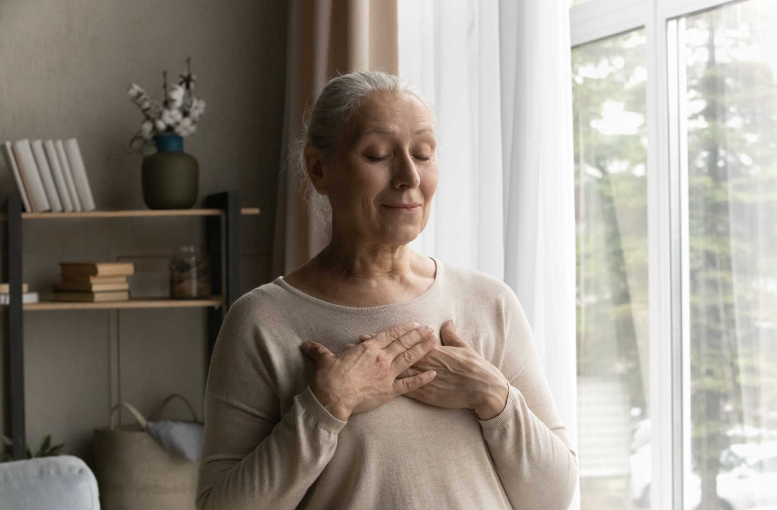 A woman praying in her apartment.