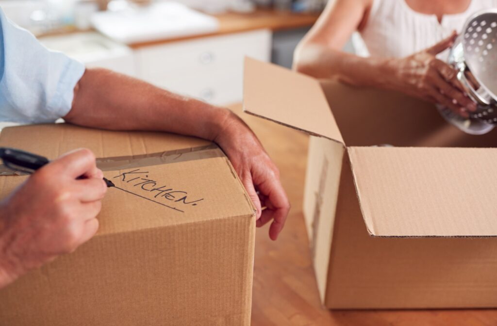 A couple organizes and labels boxes while preparing to downsize their home.